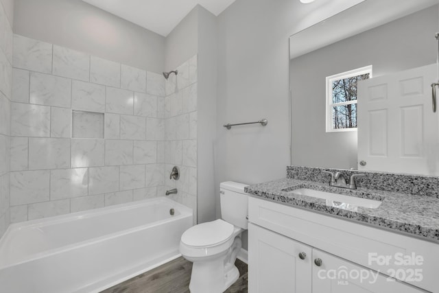 bathroom featuring toilet, bathtub / shower combination, wood finished floors, and vanity