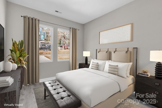 bedroom featuring wood finished floors, visible vents, and baseboards