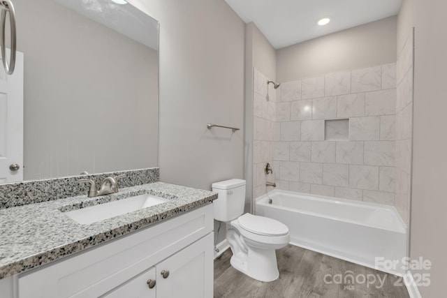 full bath featuring toilet, washtub / shower combination, wood finished floors, and vanity