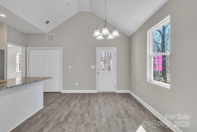 unfurnished dining area featuring light wood-type flooring, visible vents, and a wealth of natural light