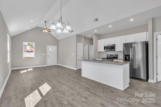 kitchen with visible vents, white cabinets, appliances with stainless steel finishes, light stone countertops, and tasteful backsplash