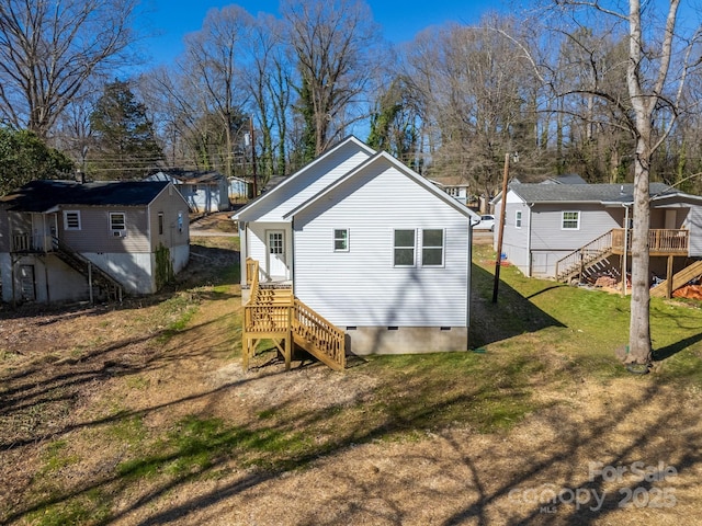 back of house with crawl space, a residential view, stairway, and a yard