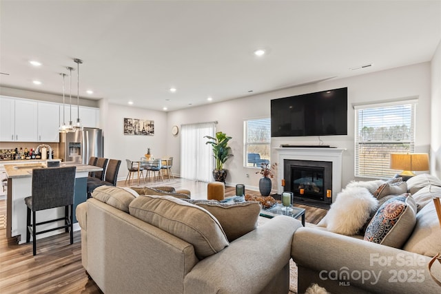 living room with plenty of natural light, recessed lighting, and wood finished floors