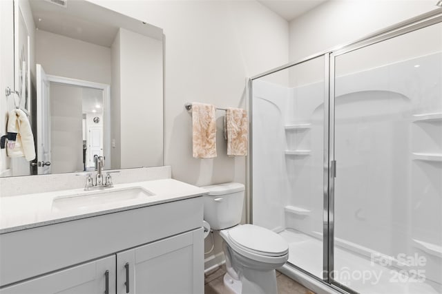 bathroom with vanity, toilet, and a shower stall