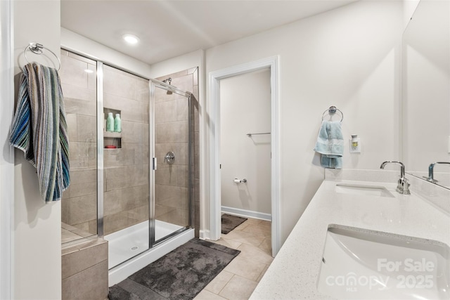 full bath with tile patterned floors, a stall shower, and a sink