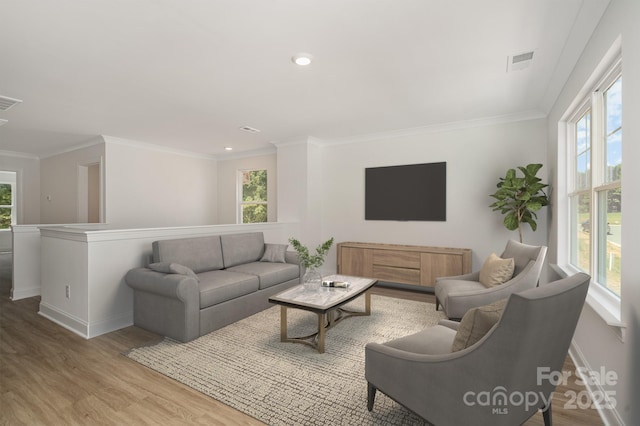 living room with plenty of natural light, wood finished floors, visible vents, and baseboards