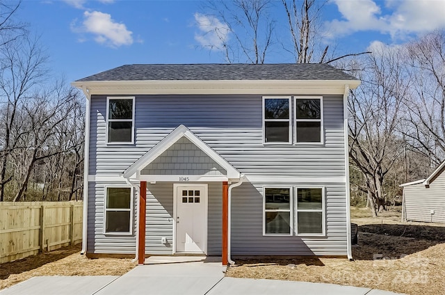 view of front of house with roof with shingles and fence