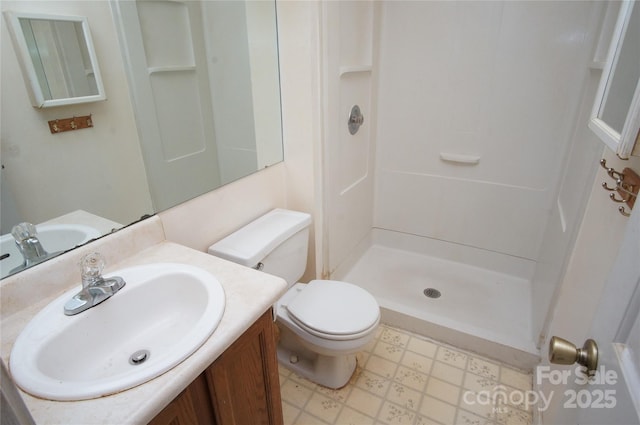 full bathroom featuring toilet, a stall shower, tile patterned floors, and vanity