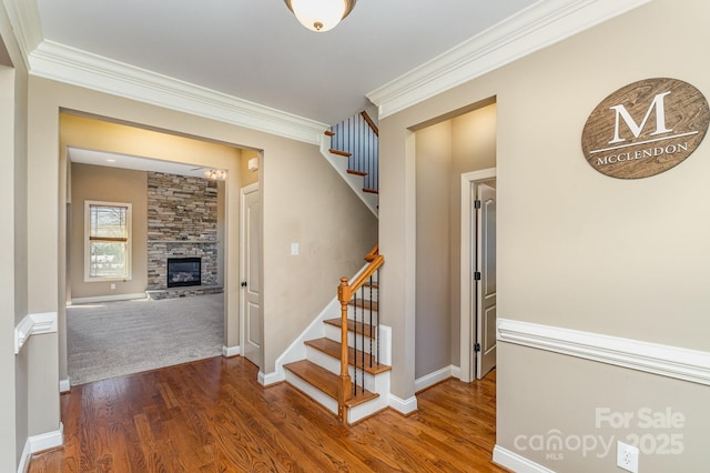 hall with crown molding, stairway, and wood finished floors