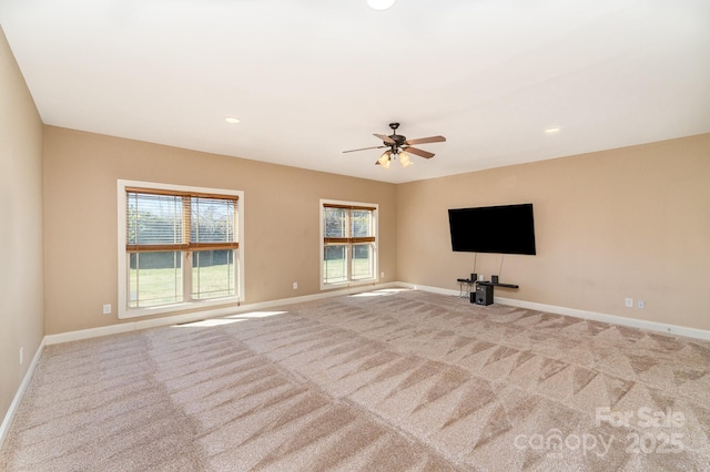 unfurnished living room featuring carpet flooring, plenty of natural light, and baseboards