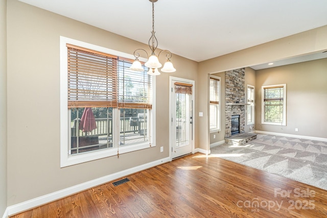 foyer with a fireplace, wood finished floors, visible vents, and baseboards