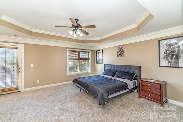 carpeted bedroom featuring a tray ceiling, multiple windows, baseboards, and crown molding