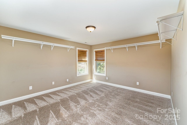 unfurnished room with carpet and baseboards