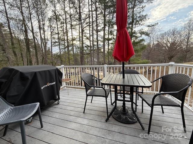 deck featuring outdoor dining space and grilling area