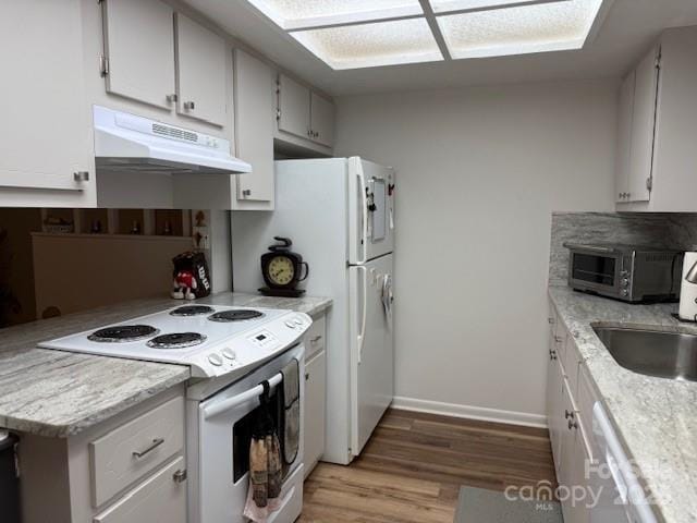 kitchen featuring light countertops, white appliances, light wood-style floors, and under cabinet range hood