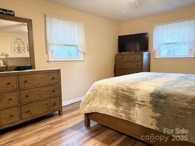 bedroom featuring wood finished floors and baseboards