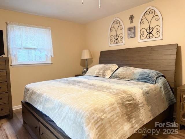 bedroom with wood finished floors and baseboards