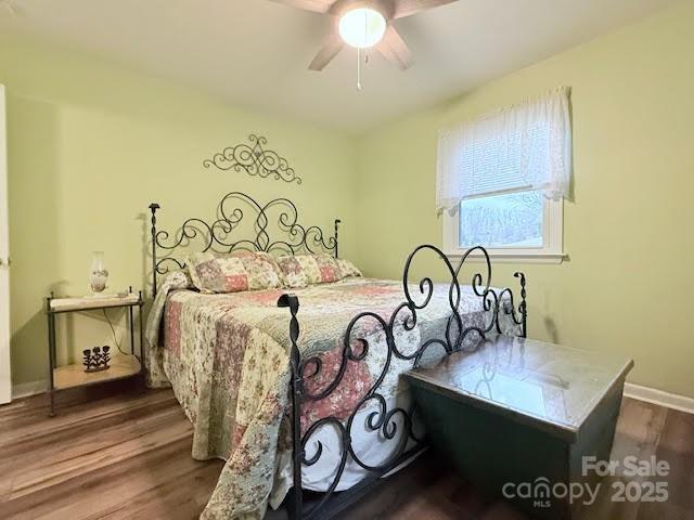 bedroom with wood finished floors, a ceiling fan, and baseboards