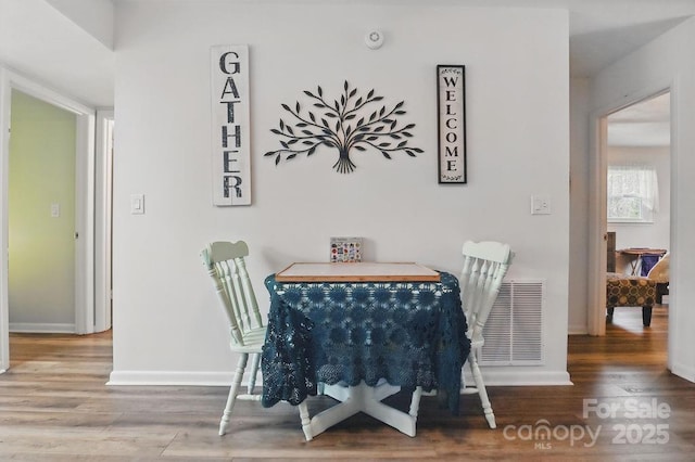 dining area with visible vents, baseboards, and wood finished floors