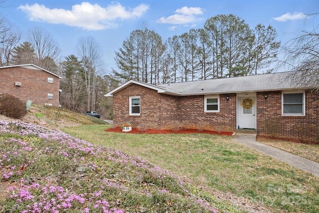 ranch-style home with a front lawn and brick siding