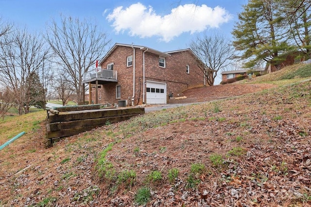 view of property exterior featuring brick siding and an attached garage