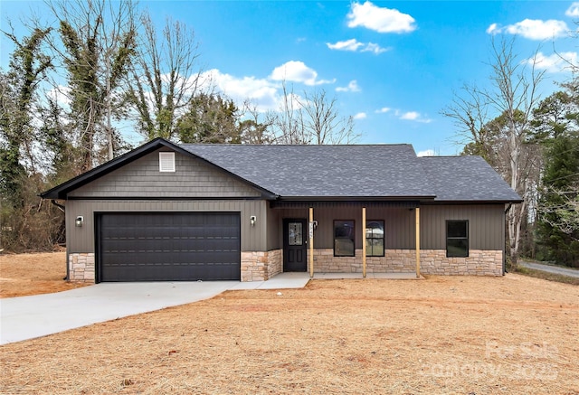 view of front of home with stone siding, an attached garage, concrete driveway, and a shingled roof