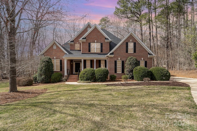 view of front of property with a yard and brick siding