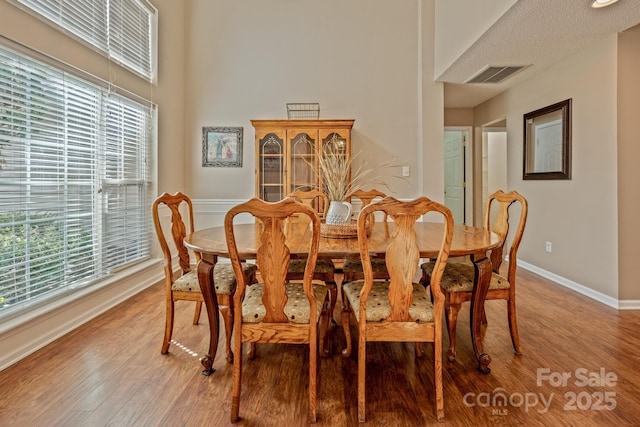 dining space with light wood-style floors, baseboards, and visible vents