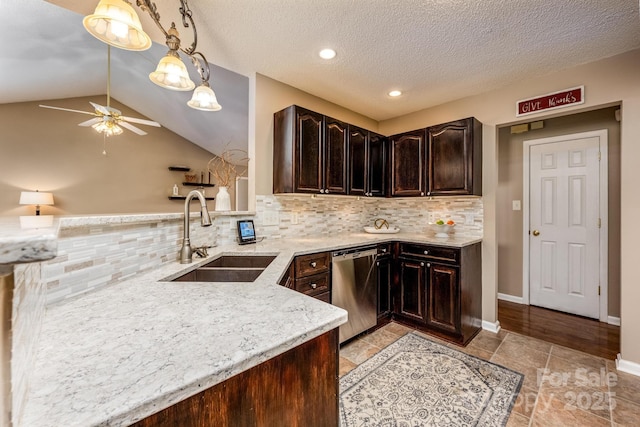 kitchen featuring lofted ceiling, a sink, dark brown cabinets, stainless steel dishwasher, and light stone countertops