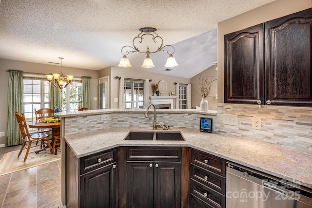 kitchen featuring a chandelier, a sink, stainless steel dishwasher, and dark brown cabinets