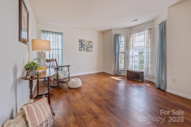 sitting room featuring a healthy amount of sunlight, visible vents, and wood finished floors