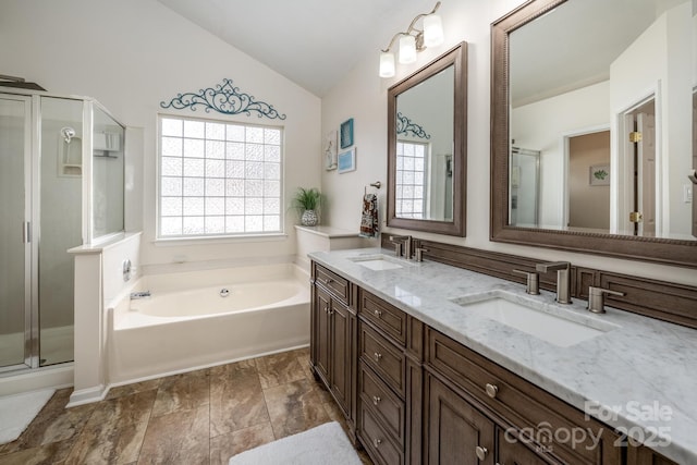 full bath with a shower stall, vaulted ceiling, and a sink