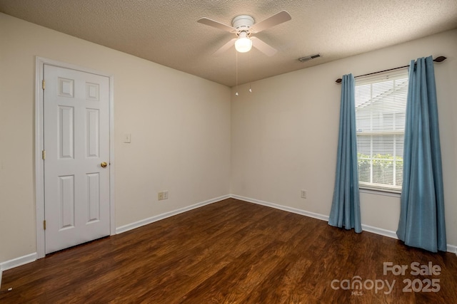 empty room featuring visible vents, ceiling fan, a textured ceiling, and wood finished floors