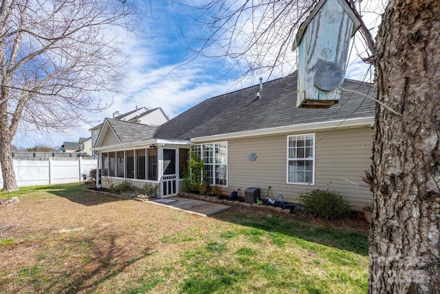 back of house with a sunroom, a yard, and fence