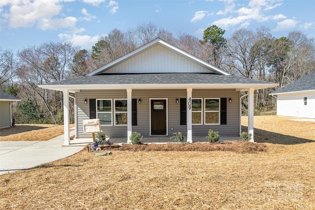 bungalow-style house featuring a porch and roof with shingles