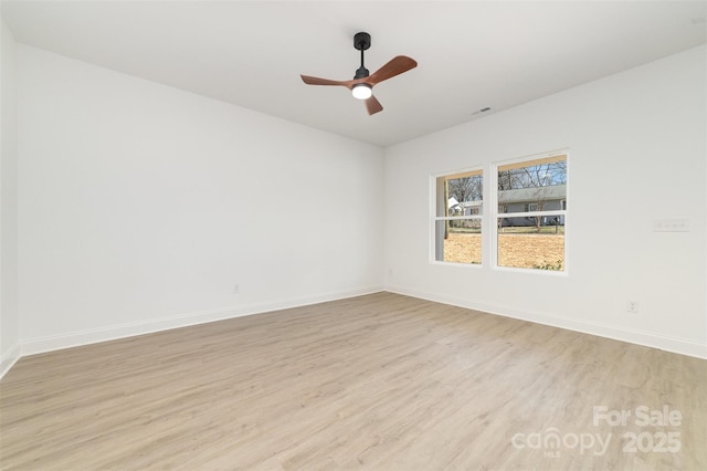 empty room with light wood-style flooring, visible vents, baseboards, and a ceiling fan