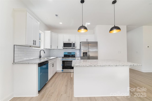 kitchen featuring tasteful backsplash, stainless steel appliances, a sink, and a center island