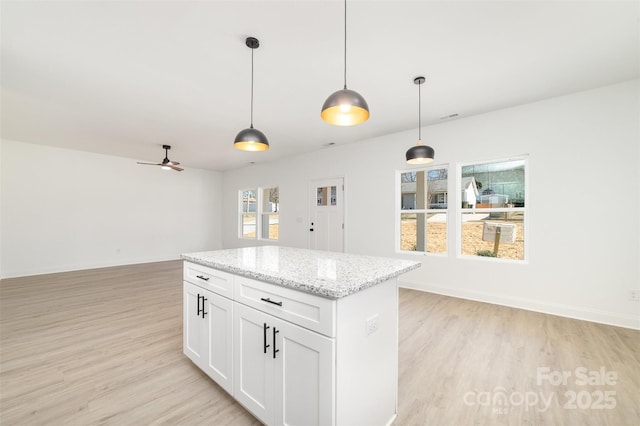 kitchen featuring light wood-type flooring, pendant lighting, a center island, and open floor plan