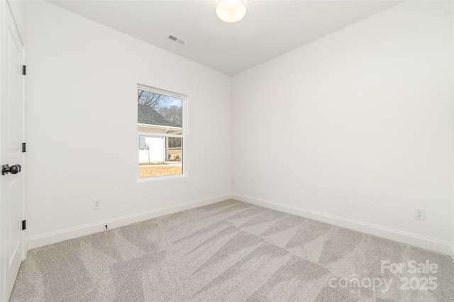 spare room with visible vents, baseboards, and light colored carpet