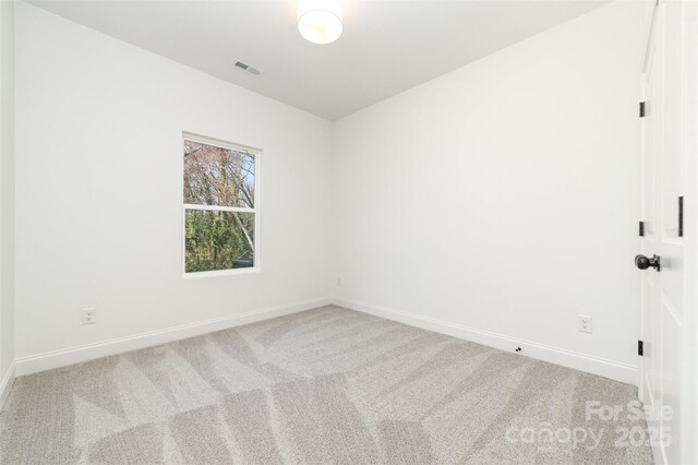 carpeted empty room with visible vents and baseboards