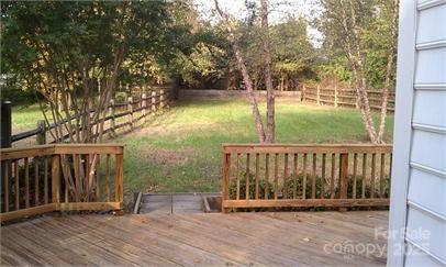 wooden terrace with a yard and fence