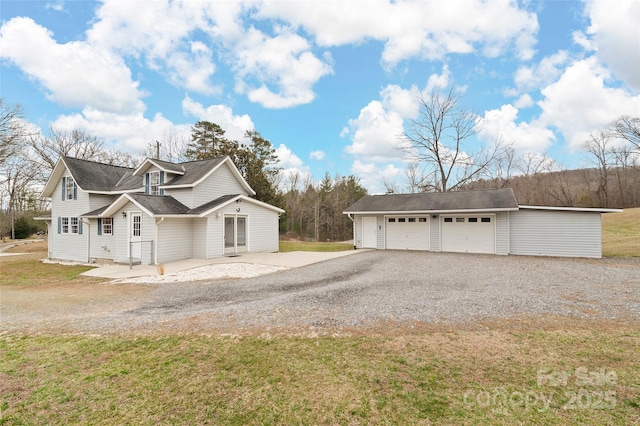 view of side of home with an outbuilding, a yard, and a garage