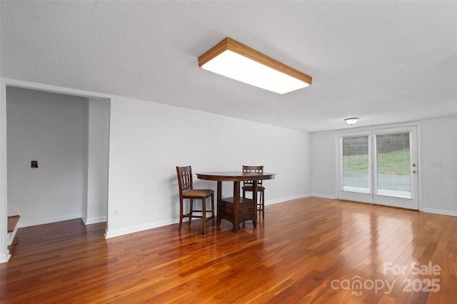 dining area with hardwood / wood-style flooring and baseboards