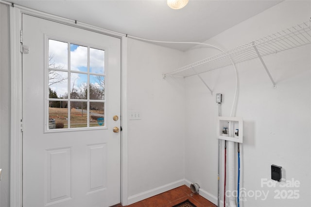 laundry area featuring baseboards, a healthy amount of sunlight, and laundry area