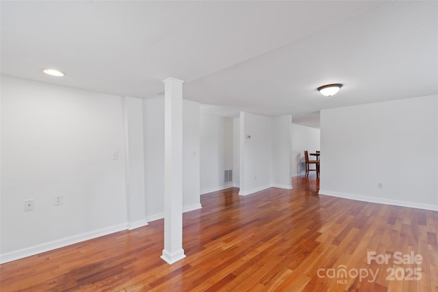 below grade area featuring visible vents, baseboards, and wood finished floors