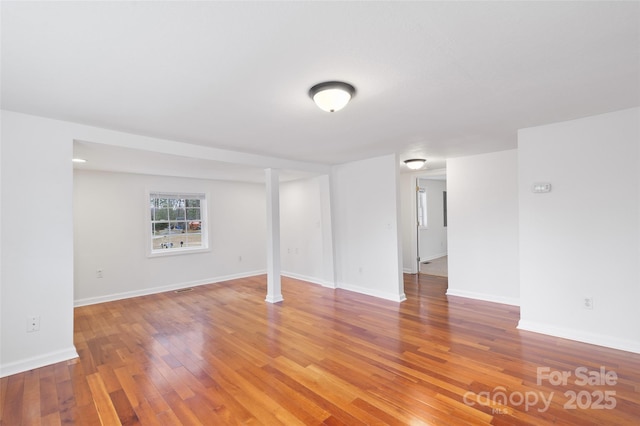 unfurnished room with baseboards and light wood-type flooring