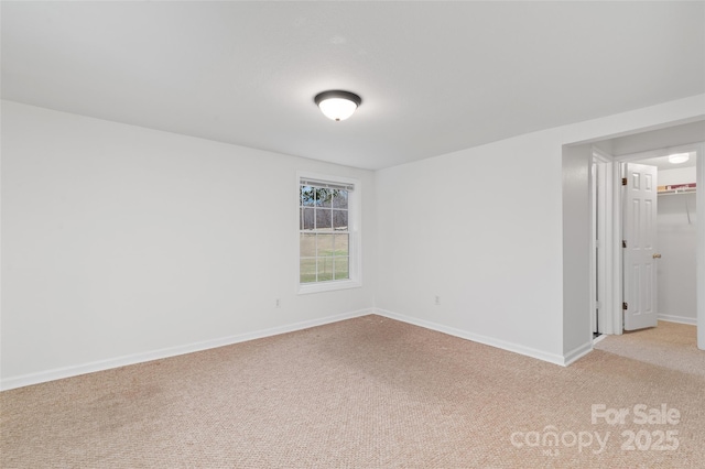 empty room with light colored carpet and baseboards