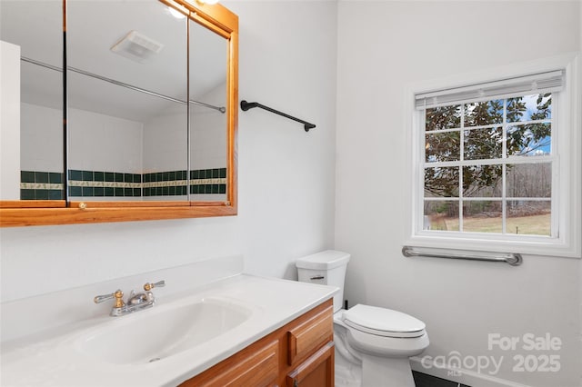 bathroom featuring visible vents, toilet, and vanity