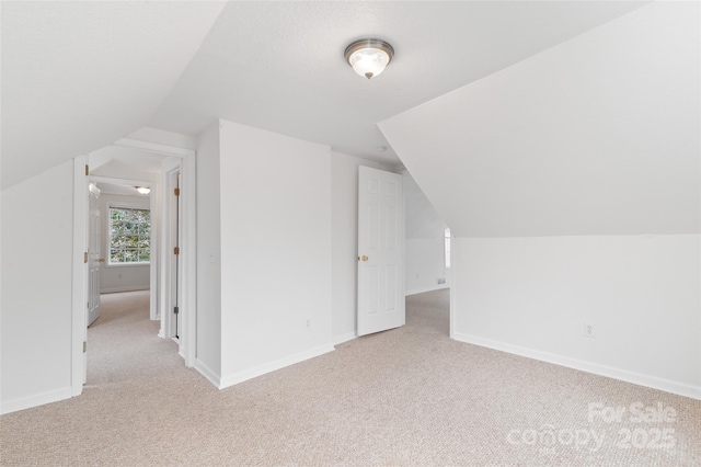 bonus room featuring light carpet and baseboards