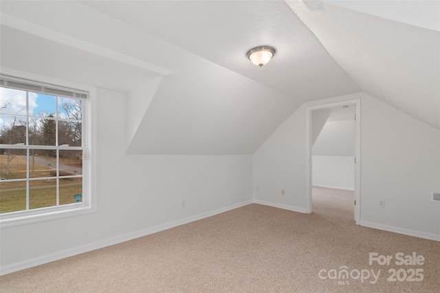 bonus room with lofted ceiling, baseboards, and carpet floors